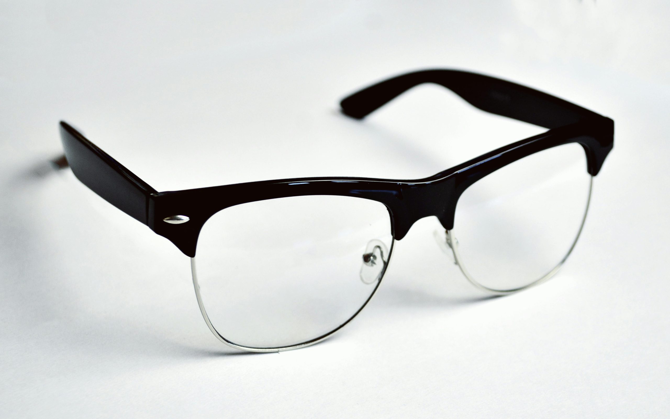 Stylish black wayfarer eyeglasses placed on a clean white background, highlighting fashion and design.