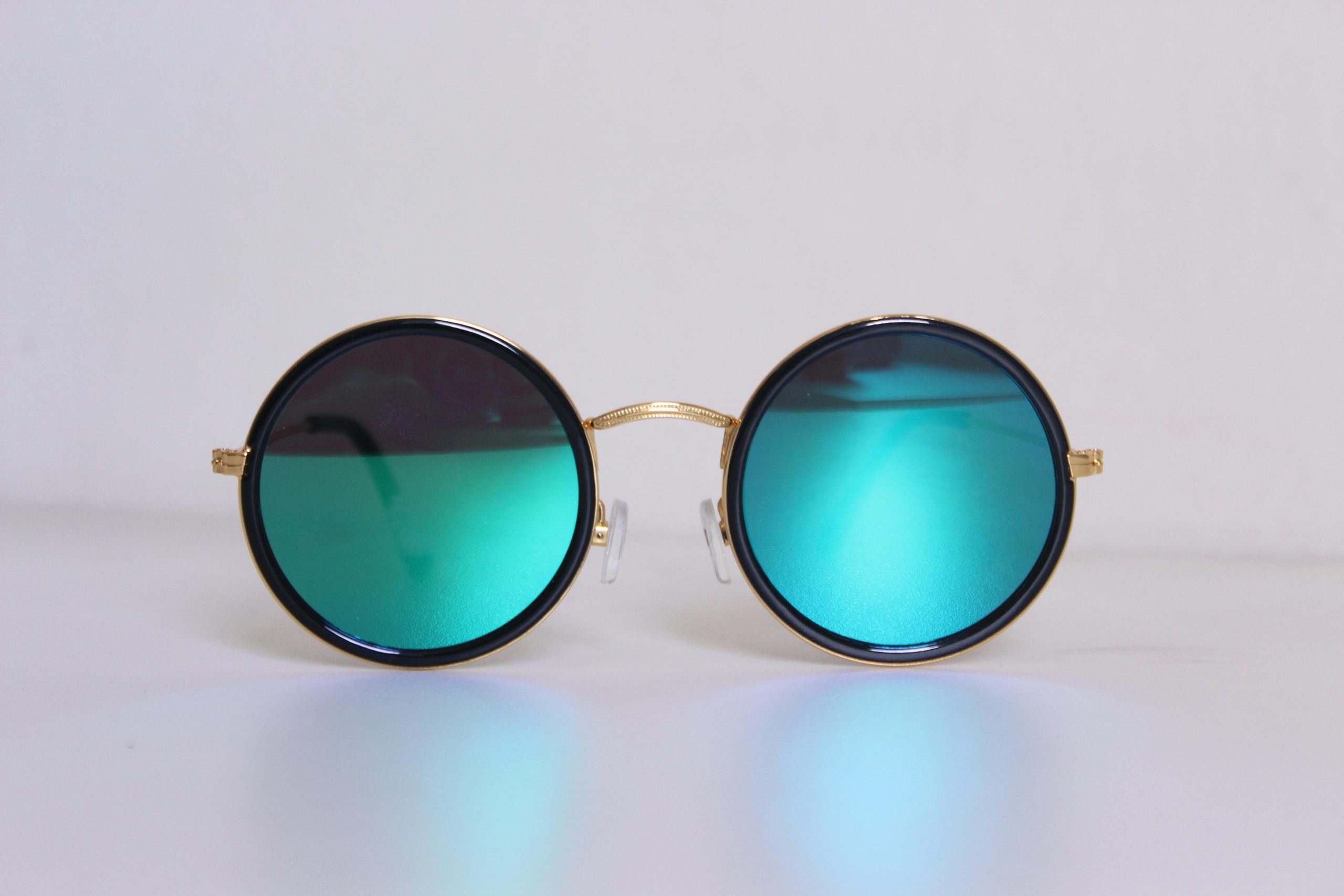 Elegant round sunglasses with blue-tinted lenses and gold frames, perfect for a trendy fashion statement.